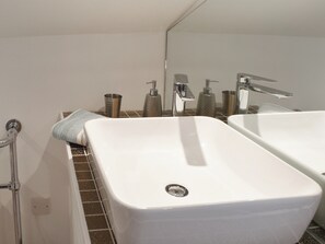 Baño con dos lavamanos, un espejo y zona de ducha.