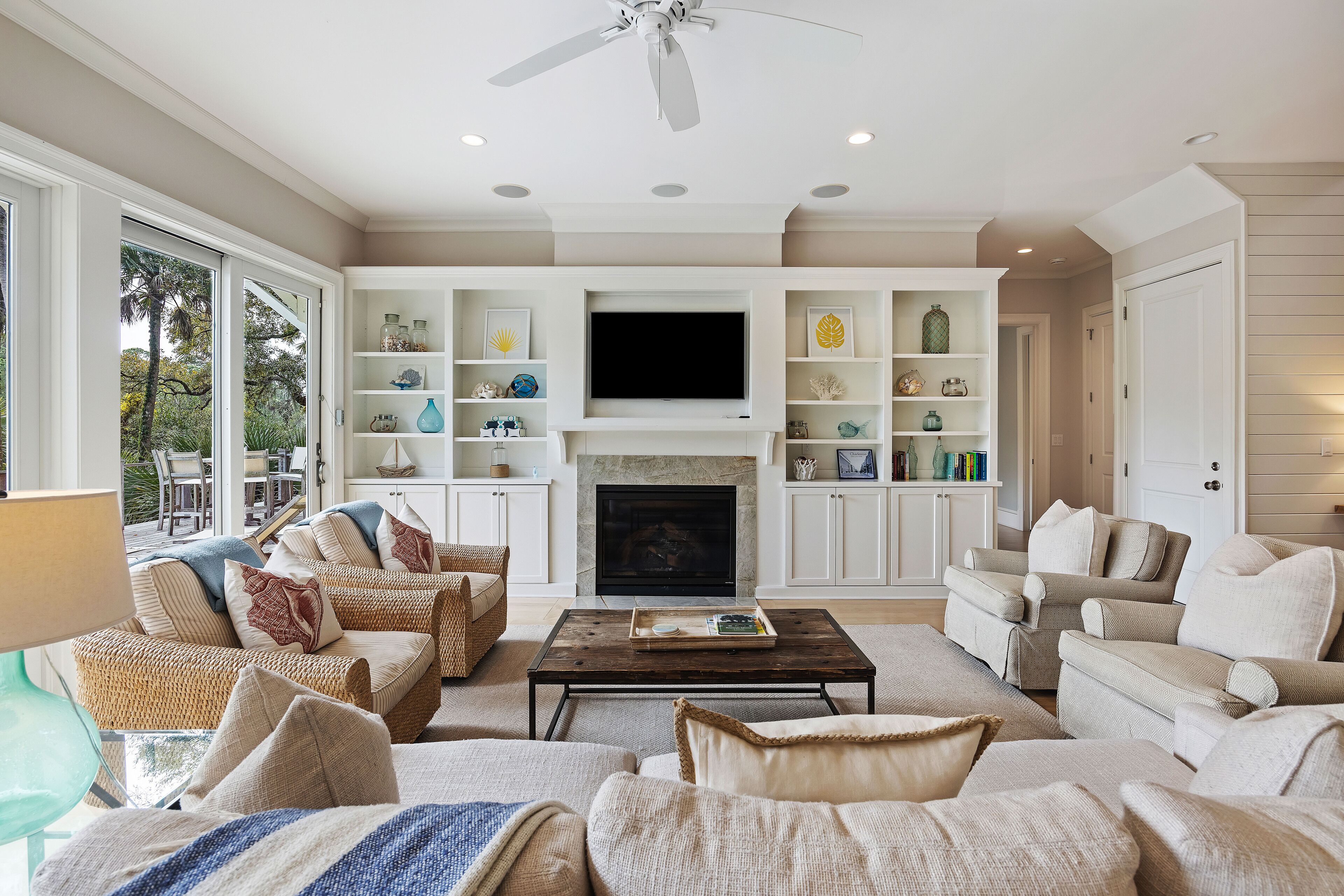 A spacious living room with a fireplace, comfortable seating, and built-in shelving with decorative items.