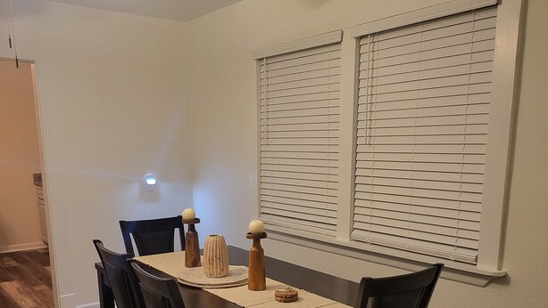 A dining area with a wooden table, four chairs, and a ceiling fan. - Aunt Mattie's Cottage (Ocean Springs)