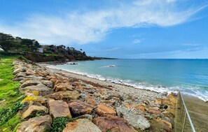 A rocky beach with a clear view of the ocean and a distant shoreline. - 4 bedroom beach front home in Plougasnou (Plougasnou)