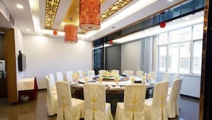 A conference room with a round table, white chairs, and red hanging lamps. - Jinjiacheng Hotel (Shantou)