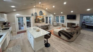 A spacious living area with a kitchen, dining space, and a fireplace.