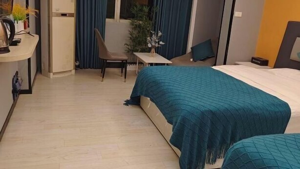 Una habitación de hotel con cama, escritorio, silla y una mesita.
