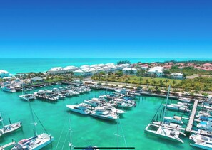 Boats docked in a well-organized marina surrounded by residential homes and lush greenery.
