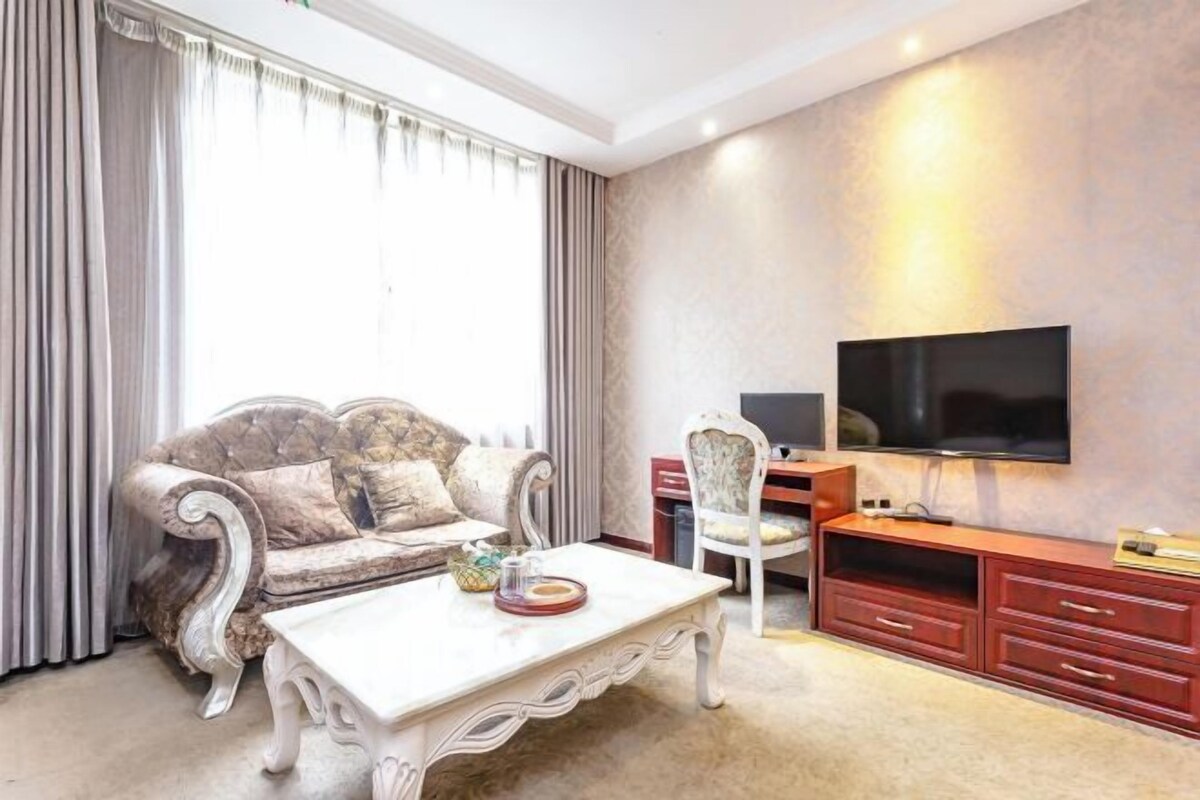 A living room with a sofa, a coffee table, a TV, and a TV stand.