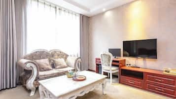 A living room with a sofa, a coffee table, a TV, and a TV stand.