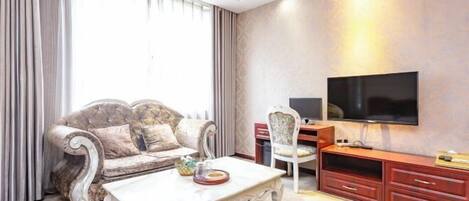 Ein Wohnzimmer mit einer Couch, einem Couchtisch, einem Fernseher und einem TV-Schrank.