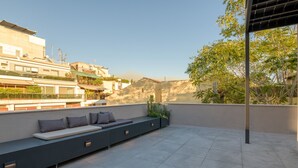 A rooftop terrace with a long bench, potted plants, and a view of surrounding buildings. - An Outstanding 3 bdrm Apartment in the Heart of Athens (Athens)