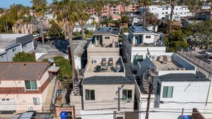 A residential area with multiple houses, some with solar panels, and a clear view of the neighborhood. - Walk to Beach, Shops, Restaurants | AC | Private Roof Deck & Fire Pit (San Diego)