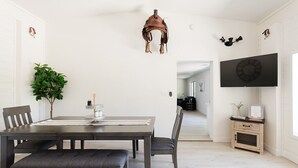 A dining area with a wooden table, chairs, a bench, a potted plant, and a mounted clock. - Riverfront Ranch, Near Wine Tasting & Sedona (Cottonwood)