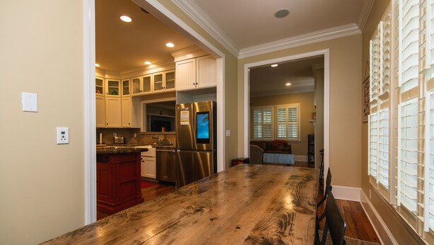 A spacious kitchen with a large wooden island, stainless steel appliances, and a view into the dining area.