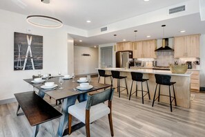 Una cocina moderna con armarios de madera, una isla central y taburetes de bar.