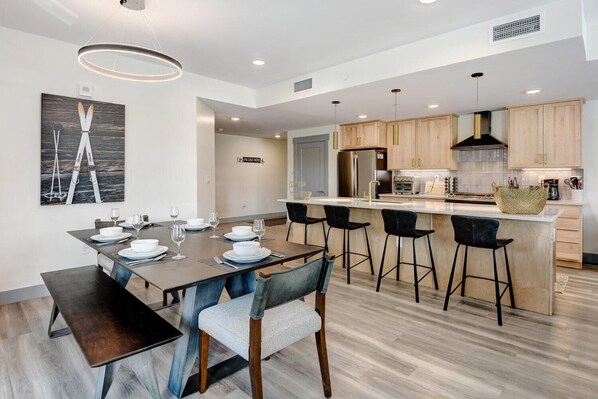 Una cocina moderna con armarios de madera, una isla central y taburetes de bar.