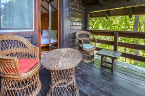 A wooden deck with wicker furniture, including two chairs and a small table. - Mountain Family Chalet (Comarnic)
