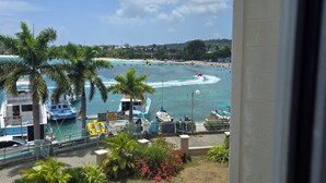 A view of a beach with boats, palm trees, and a clear sky. - Sweets Beach View in the heart of  Ocho Rios (Ocho Rios)