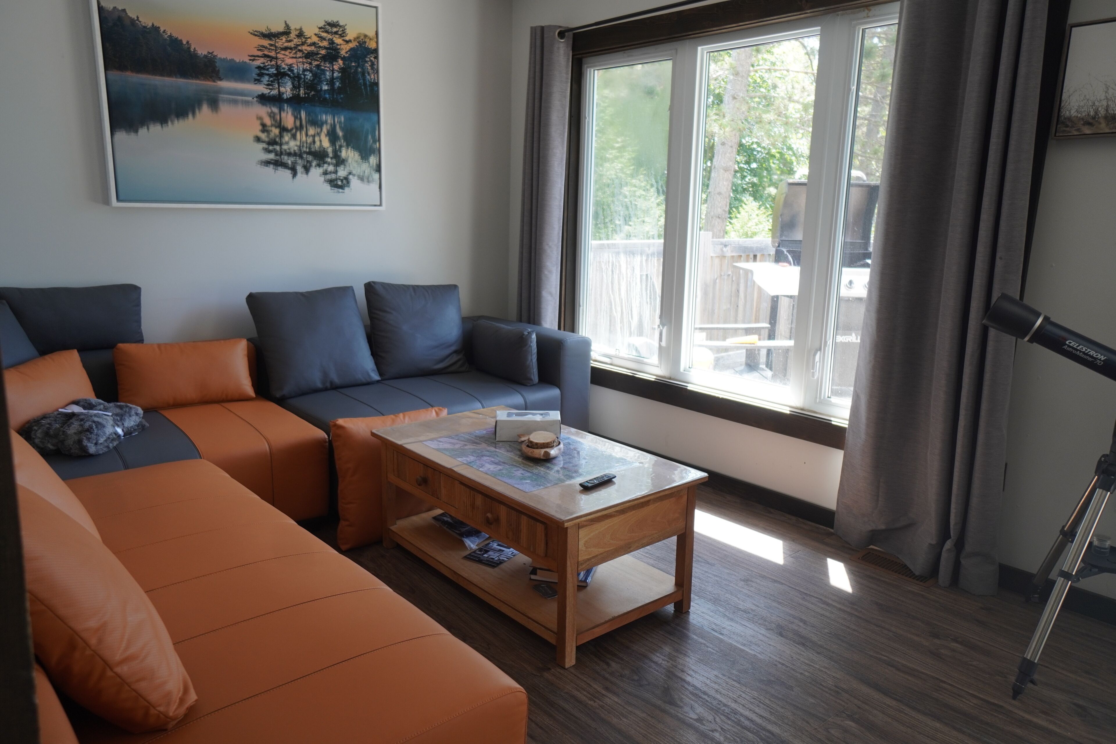 A modern living room with a sectional sofa, a coffee table, and a large window with curtains.