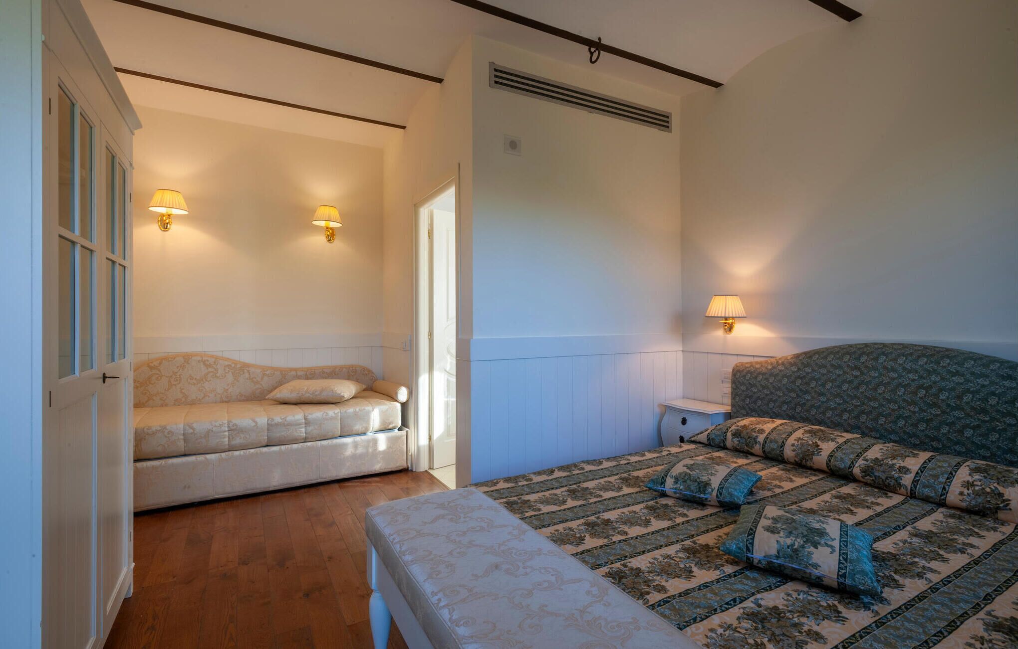 A bedroom with a bed, a bench, and two nightstands.