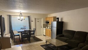 A compact living space with a dining area, kitchen, and seating area.