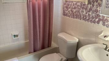 Un baño con bañera, inodoro y lavabo.