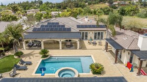 A house with a swimming pool, solar panels, and a patio with outdoor furniture. - Hidden Gem of SoCal: Game Room, Pool, Spa, & Resort Backyard!  (Vista)