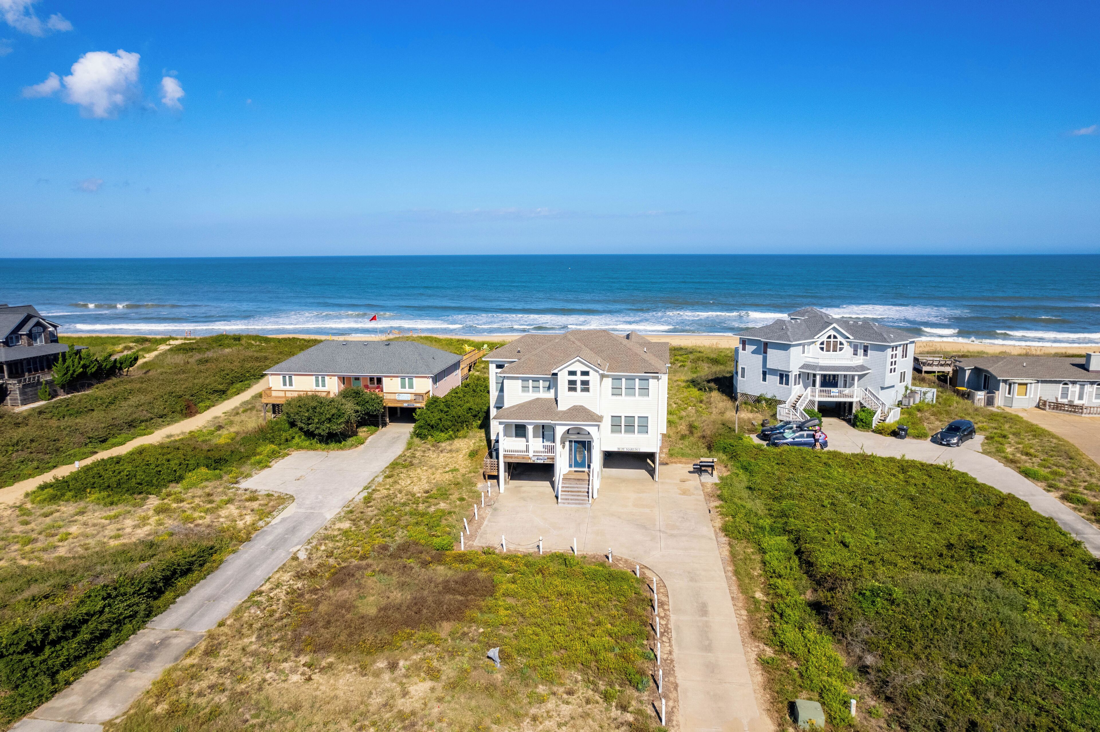 Una zona residenziale sul lungomare, con case, spiaggia e cielo sereno.