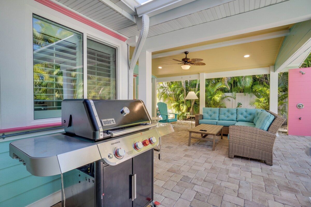 An outdoor patio with a grill, a sofa, and a ceiling fan.
