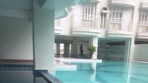 An indoor swimming pool with a tiled floor and a clear blue water surface. - Condo unit at Tagaytay Prime residences (Tagaytay)