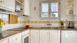 A kitchen with white cabinets, a granite countertop, a stove, a sink, and a window with blinds. - AIGUES: Beautiful house with private swimming pool in l'Escala (L'Escala)