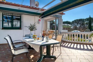 An outdoor patio with a table set for dining, chairs, and a potted plant. - AIGUES: Beautiful house with private swimming pool in l'Escala (L'Escala)