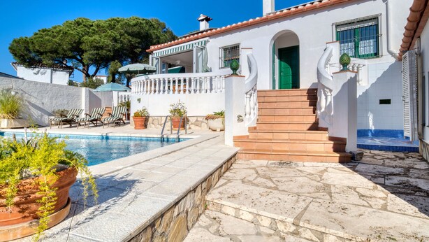 A white villa with a swimming pool, outdoor seating, and a staircase leading to a green door. - AIGUES: Beautiful house with private swimming pool in l'Escala (L'Escala)