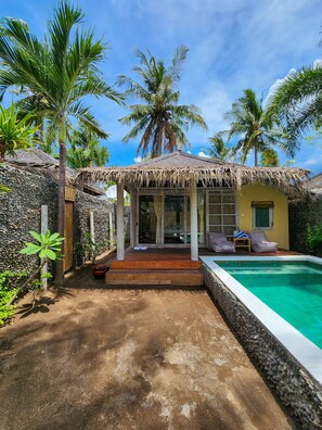 A tropical villa with a swimming pool, a thatched-roof structure, and lush greenery. - Bamboo Lodge Private Villa (Gili Trawangan)