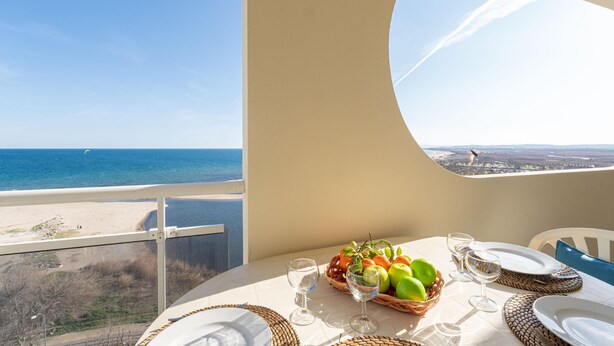 A table set for dining with a view of the beach and ocean. - Pleasant apartment with sea view (Empuriabrava)