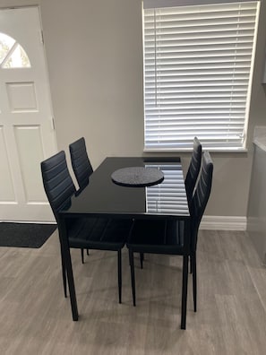 Un comedor con una mesa rectangular y seis sillas negras.