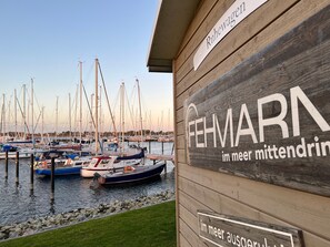 Ein Holzbau mit Schildern, auf denen 'Ruhewagen' und 'FEHMARN im Meer Mitte Drink' steht.