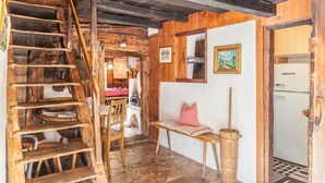 A rustic interior with a wooden staircase, a bench, a wall-mounted picture, and a refrigerator. - Holiday Home "Stoffelhäusl" with Mountain View, Private Garden and Wi-Fi (Reith im Alpachtal)