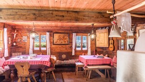 A rustic wooden interior with a dining area, benches, and a fireplace. - Holiday Home "Stoffelhäusl" with Mountain View, Private Garden and Wi-Fi (Reith im Alpachtal)