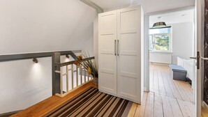 A staircase with a striped carpet, a white door, and a view of the outdoors. - Vacation Home "Insel Hus" with Private Terrace, Garden & Wi-Fi (Fehmarn)