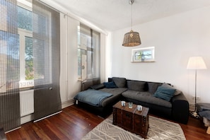 A modern living room with a sectional sofa, a wooden coffee table, and a floor lamp.