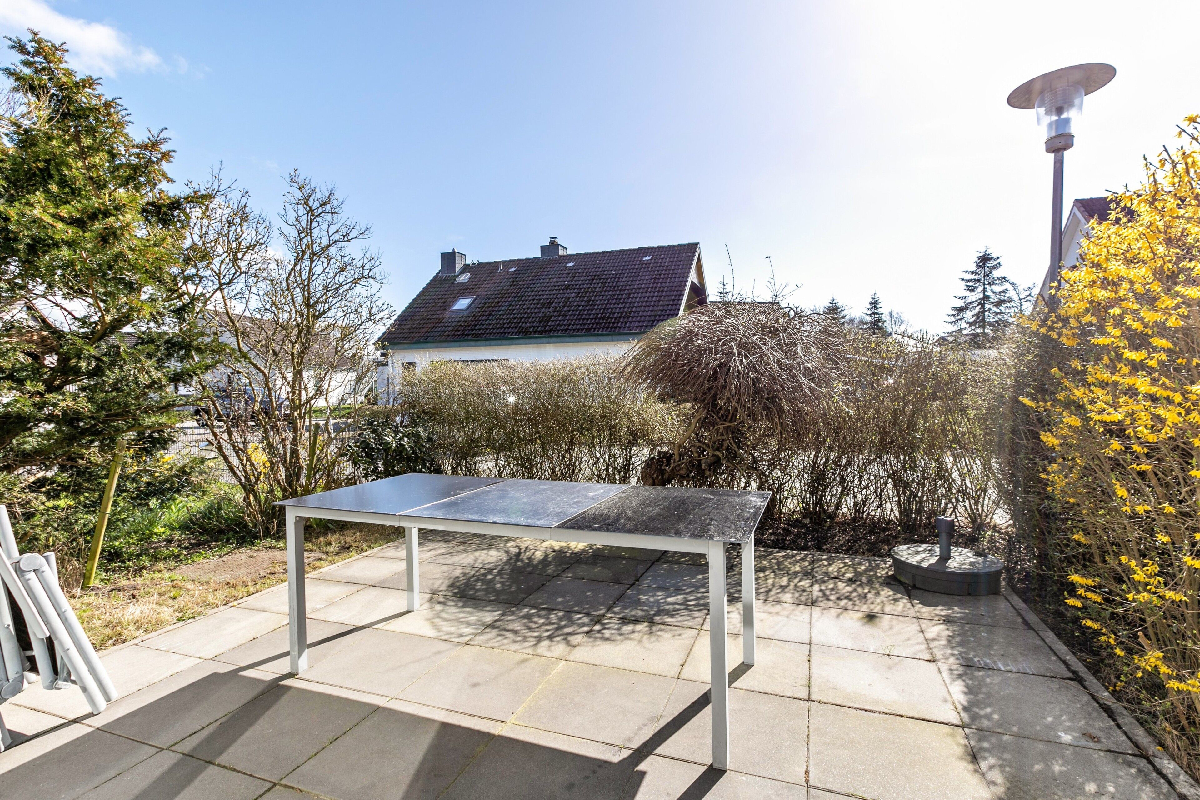 A solar-powered table in a garden with a house in the background.