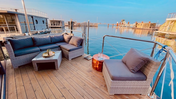 A deck with a sofa, a small table, and a chair.