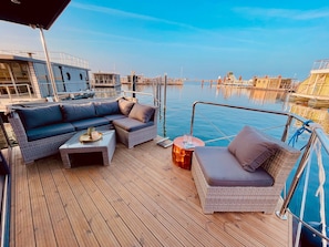 Une terrasse avec un canapé, une petite table et une chaise.
