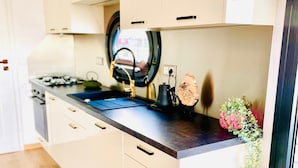 A modern kitchen with a stove, sink, and cabinets.