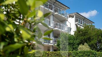 Un edificio residenziale a più piani con balconi, immerso nel verde.