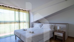 Ein Hotelzimmer mit Bett, Nachttisch und einem Vorhangfenster.