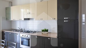 Eine moderne Küche mit Edelstahlgeräten, einem Backofen und einem Kühlschrank.