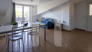 Un appartement moderne comprenant un coin repas, un canapé et un balcon.