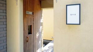 A wooden door with a small window, a wall-mounted sign with Japanese text, and a tiled floor. - vacation inn  Izu Kogen (Ito)