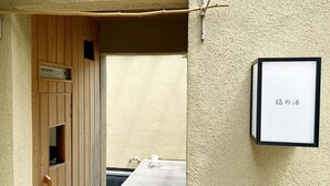 A wooden door with a small window, a framed sign with Japanese characters, and a table with a glass pitcher and a bottle. - vacation inn  Izu Kogen (Ito)