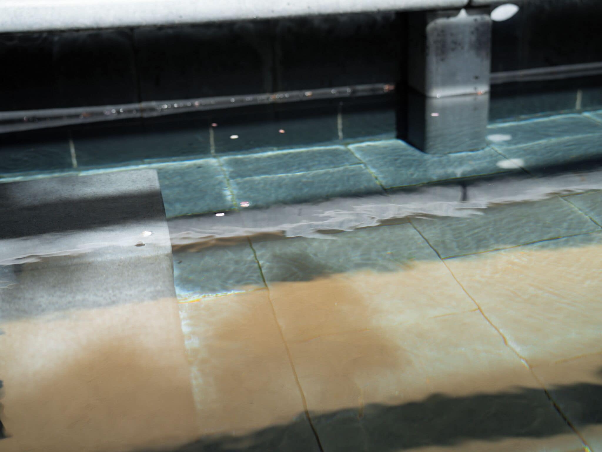 A tiled floor with a visible stain and a metal structure.