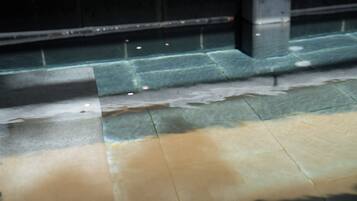 A tiled floor with a visible stain and a metal structure.